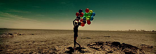 Девушка с воздушными шарами бежит по пустыне